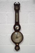 An Edwardian mahogany wheel barometer with dry/damp dial above a convex mirror,