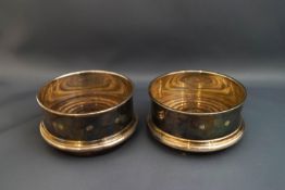 A matched pair of silver coasters, Birmingham 1988 and 89, the silver mounts with feature hallmarks,