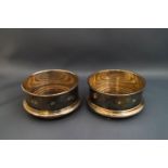 A matched pair of silver coasters, Birmingham 1988 and 89, the silver mounts with feature hallmarks,