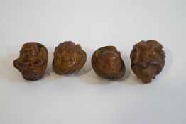 Four unusual carved nuts, depicting a winged figure reading a book, a demon, head of a creature,