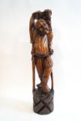 A Japanese carved hardwood figure of a man with outstretched arm towards a yokai (?) 63cm high