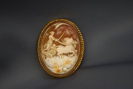A shell cameo brooch, stamped '9ct', carved as a female driving a chariot through clouds, 4.