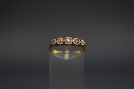 A five stone diamond ring, stamped '18ct', the graduated stones illusion set, finger size M, 2.