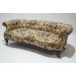 A Victorian sofa with low button back on turned legs with brass casters,