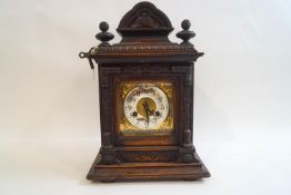 A late Victorian oak cased eight day mantel clock by Junghams, with pendulum and key,