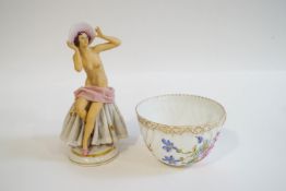 A Dresden bisque porcelain figure of a seated nude wearing a bonnet on a lace covered seat,