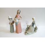 Three Lladro figures: Girl in a pink dress and bonnet, 26cm high, Seated girl with dove,