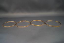 A collection of four 9 carat gold bangles,