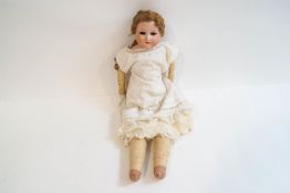 A late 19th century Armand Marseille bisque head doll with porcelain arms and cloth bandaged legs,
