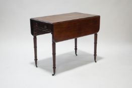 A Victorian mahogany pembroke table on ring turned tapering legs and brass casters,