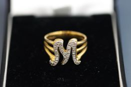 A 9 carat gold initial M ring, the letter set with single cut diamonds, finger size Q, 6.