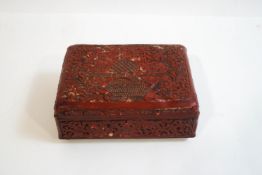 A Chinese cinnabar lacquer box with carved decoration of scrolling foliage,