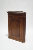 A 19th century oak corner cupboard, with canted corners and detail frieze,