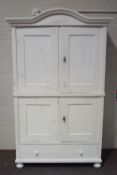 A French style painted pine armoire, the cupboard doors enclosing shelves above a base drawer,