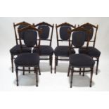 A set of six Edwardian beech dining chairs with turned uprights, padded slats,
