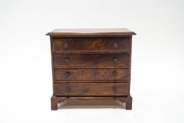 A George III style mahogany table top set of four drawers, with brass handles, upon bracket feet,