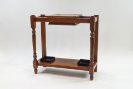 A Victorian mahogany stick stand with central storage box with hinged cover, on turned supports,