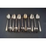 A set of eleven William IV silver old English pattern tea spoons with script initials,