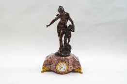 A late 19th century French mantel clock, surmounted by a figure a scantily clad female and cherub,