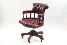 A 20th century swivel office chair with red leather button back and seat