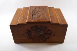 A Chinese camphorwood box with carved detail of figures to the stepped lid and sides,