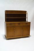 An Ercol style elm dresser with two tier plate rack over three drawers and cupboards,