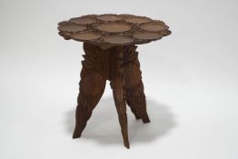 A hardwood occasional table, the top covered in low relief with lily pads,