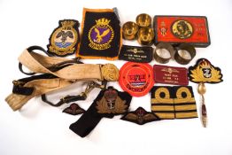 A collection of military badges, braces and shell cases,