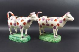 A pair of Staffordshire earthenware cow creamers,
