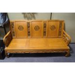 A Chinese hardwood three seat sofa with carved pierced back and solid seat,