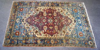 A Persian rug with central lobed medallion and stylised floral pattern to the field,