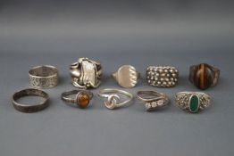 Ten various silver or white metal rings including an oval cabochon tigers eye ring,
