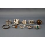 Ten various silver or white metal rings including an oval cabochon tigers eye ring,