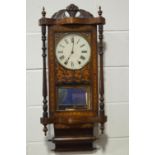 An early 20th century American wall clock with eight day movements, pendulum and winding key,