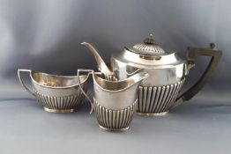 A silver oval part fluted three piece tea service in Queen Anne style,