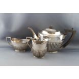 A silver oval part fluted three piece tea service in Queen Anne style,