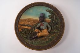 An Austrian terracotta dish with a negro figure in relief, by Johann Maresch,