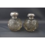 A pair of late Victorian silver mounted clear cut glass spherical scent bottles,