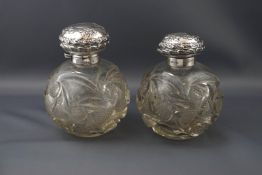 A pair of late Victorian silver mounted clear cut glass spherical scent bottles,