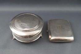 A round silver trinket box with engraved inscription to the hinged cover, on three flared feet,