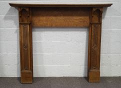 An Edwardian oak fire surround, carved reeded columns to each side with flower roundel detail,