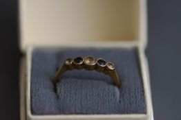 An early 20th century blue and colourless paste graduated five stone ring, stamped '18ct & Plat',