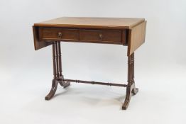 A Regency style mahogany sofa table with turned supports and stretcher joining outswept legs,