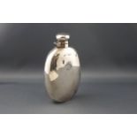 An early 20th century silver oval 6 3/4oz hip flask with a hinged twist cover,