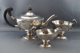 A silver round pedestal three piece tea service, each with gothic cut-card decoration,