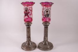 A pair of Russian plated copper candlesticks, the bases decorated with figures of kings,