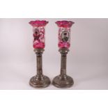 A pair of Russian plated copper candlesticks, the bases decorated with figures of kings,