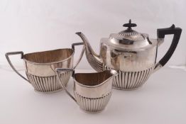 A plated oval part fluted three piece tea service in Queen Anne style.