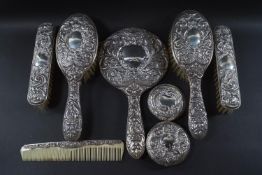 A Victorian style four piece embossed silver backed dressing table set comprising of a pair of hair