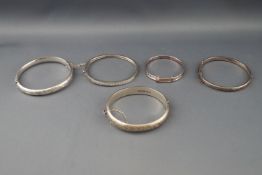 Five various silver or white metal bangles